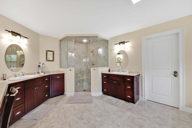 bathroom featuring a sink, two vanities, a shower stall, and baseboards