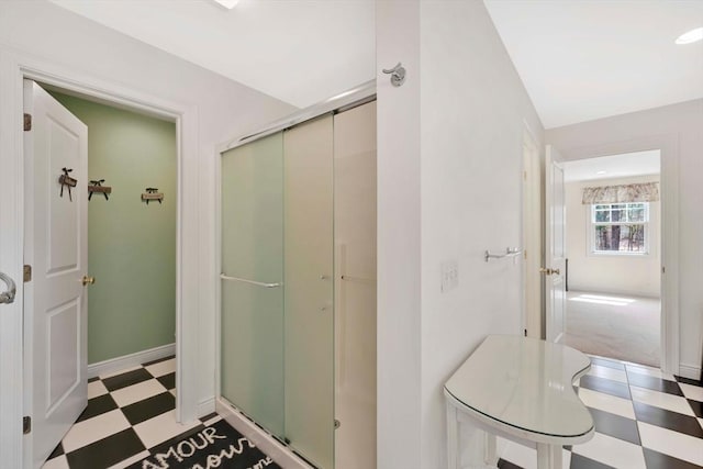 bathroom with a shower stall, tile patterned floors, and baseboards