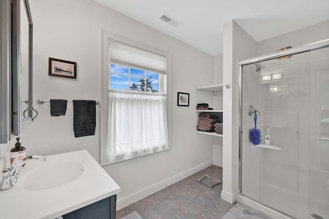 bathroom with visible vents, baseboards, a shower stall, vanity, and tile patterned flooring