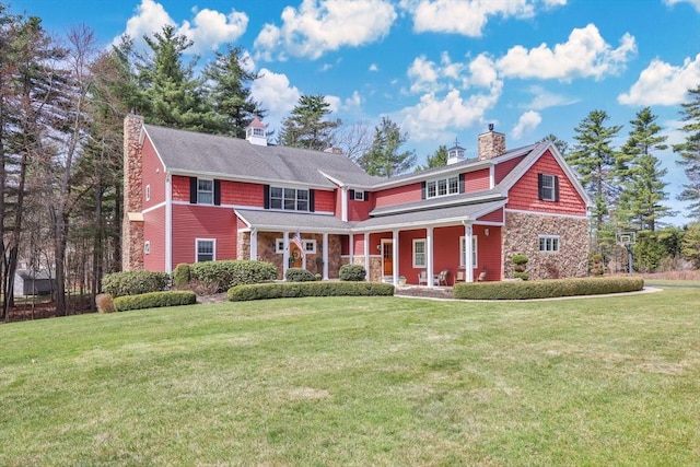 view of front facade featuring a porch, stone siding, a chimney, and a front lawn