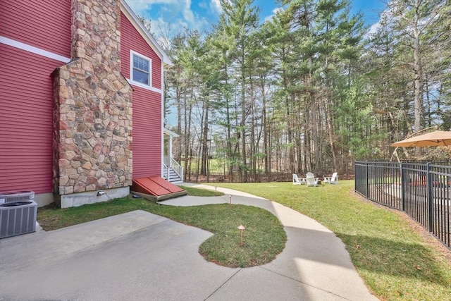 view of yard featuring a patio area, fence, and central air condition unit