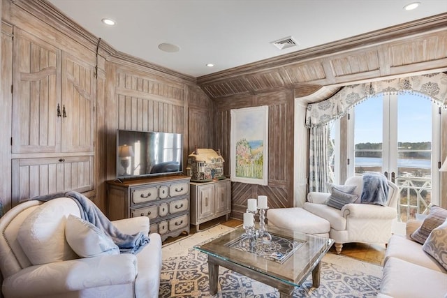 interior space featuring ornamental molding, wooden walls, and french doors