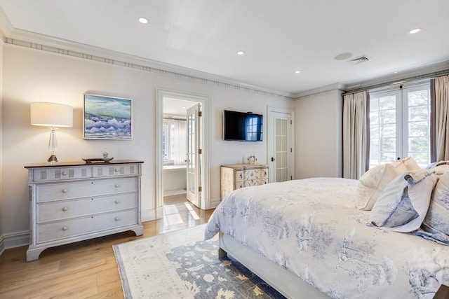 bedroom with multiple windows, connected bathroom, ornamental molding, and light hardwood / wood-style floors