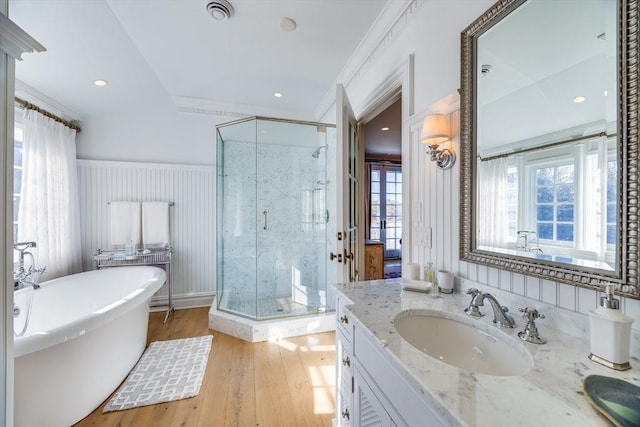 bathroom with independent shower and bath, crown molding, hardwood / wood-style floors, and vanity