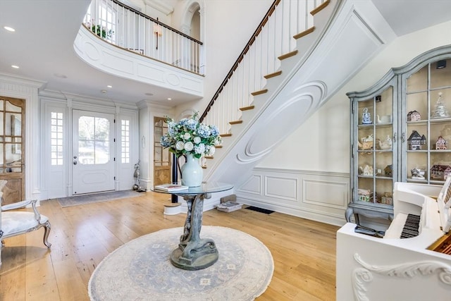 foyer entrance with ornamental molding and light wood-type flooring