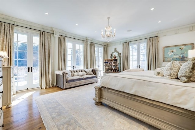 bedroom featuring access to exterior, light hardwood / wood-style flooring, ornamental molding, and french doors