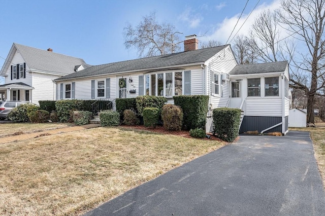 view of front of home featuring a chimney and a front yard