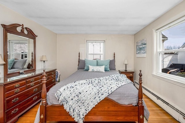 bedroom featuring a baseboard radiator and light wood finished floors