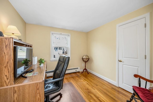 office area with a baseboard radiator, baseboards, and wood finished floors