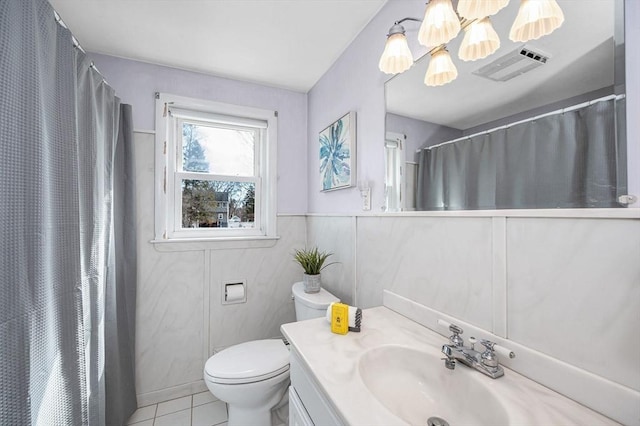 full bathroom with vanity, a wainscoted wall, visible vents, tile patterned flooring, and toilet