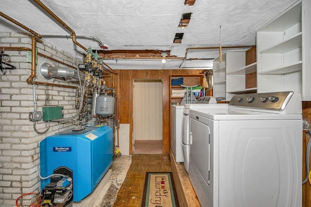 laundry room featuring independent washer and dryer, a heating unit, brick wall, and laundry area