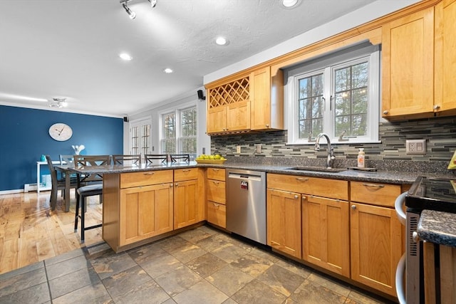 kitchen with a breakfast bar, stainless steel appliances, decorative backsplash, a sink, and a peninsula