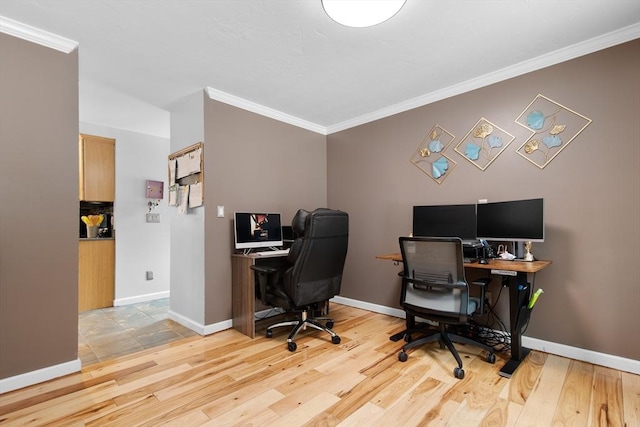 home office with light wood-style floors, ornamental molding, and baseboards