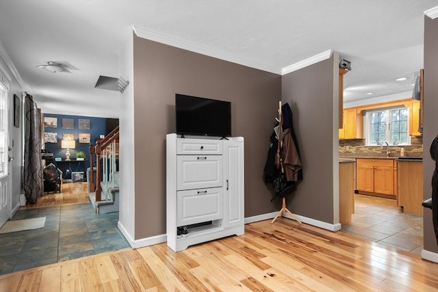 interior space with baseboards, stairway, light wood-style flooring, and crown molding