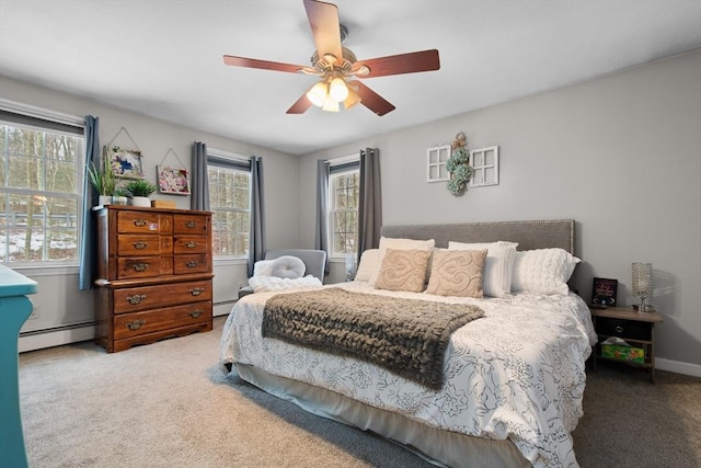 carpeted bedroom featuring a baseboard heating unit, ceiling fan, and baseboards