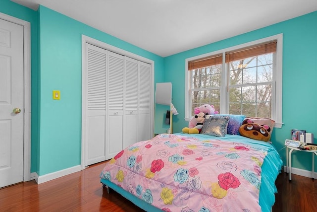 bedroom with a closet, wood finished floors, and baseboards