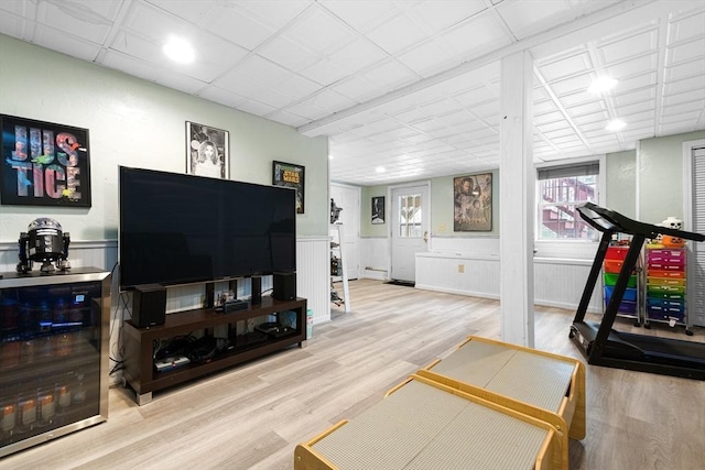 workout room featuring wainscoting and wood finished floors