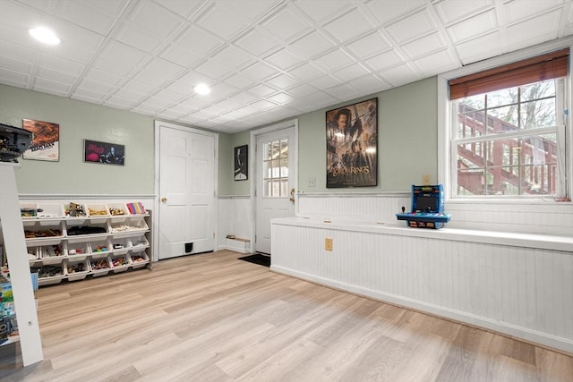 interior space featuring light wood-type flooring and a wainscoted wall