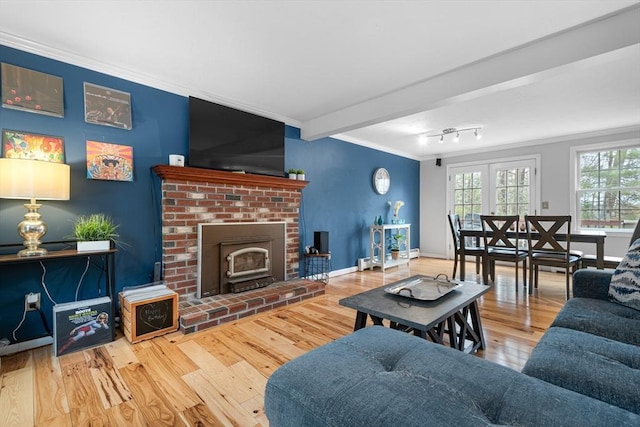 living room featuring ornamental molding, wood finished floors, and baseboards