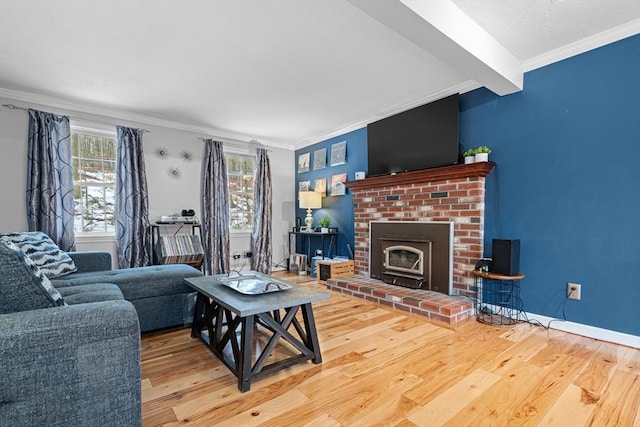 living area with a brick fireplace, baseboards, crown molding, and wood finished floors