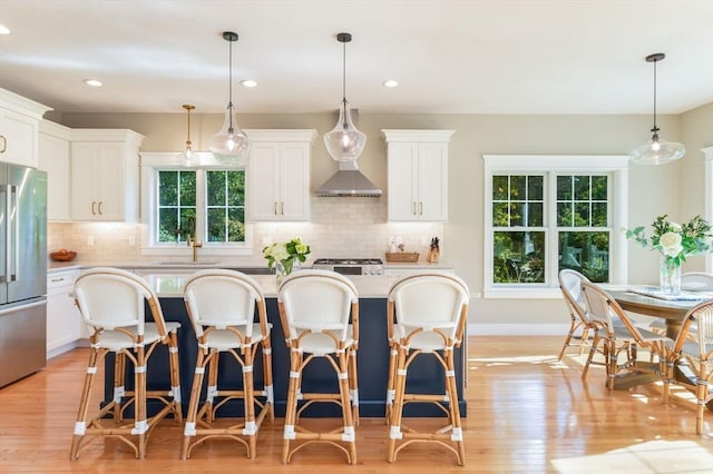 kitchen with pendant lighting, white cabinetry, high end refrigerator, and a kitchen island