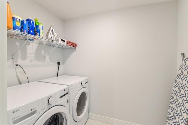 laundry room with washer and clothes dryer and light tile patterned floors