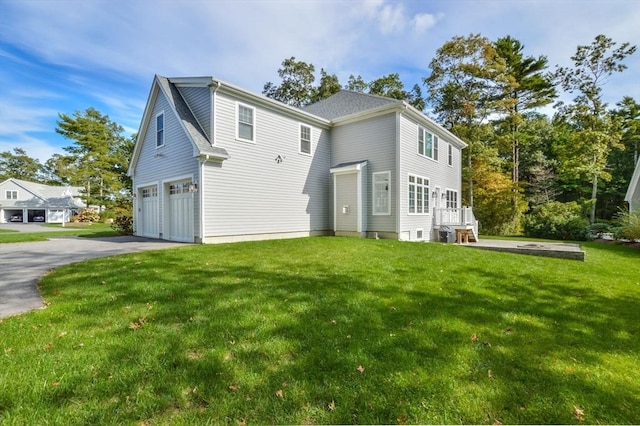 rear view of property with a yard and a garage