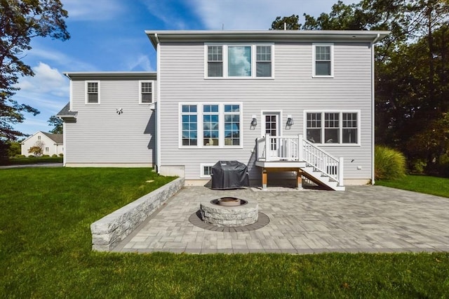 back of property featuring an outdoor fire pit, a yard, and a patio