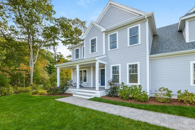 view of front of home with covered porch and a front lawn