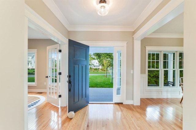 doorway to outside featuring crown molding and light hardwood / wood-style floors