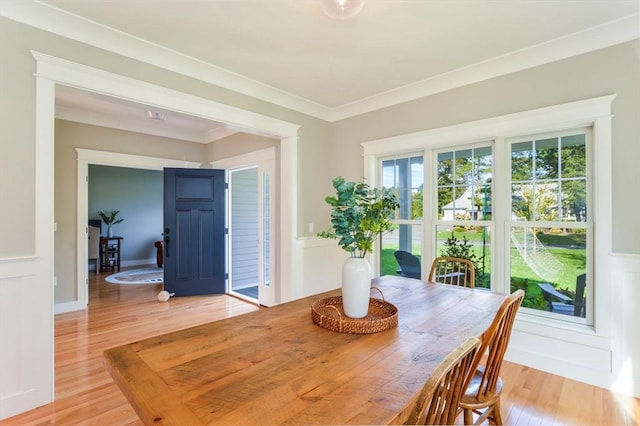 dining space featuring ornamental molding and light hardwood / wood-style floors