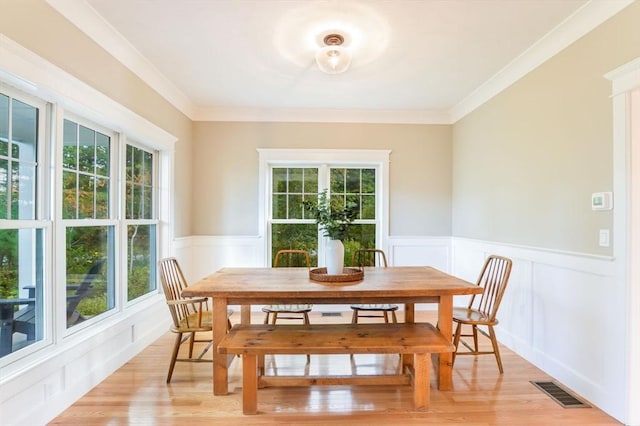 dining area with crown molding and light hardwood / wood-style flooring