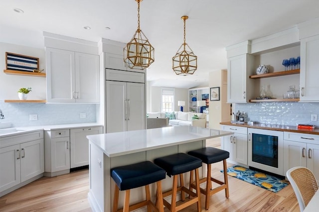 kitchen featuring light wood-style floors, open shelves, backsplash, and beverage cooler