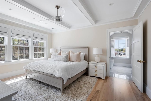 bedroom featuring baseboards, ornamental molding, light wood-style flooring, and multiple windows