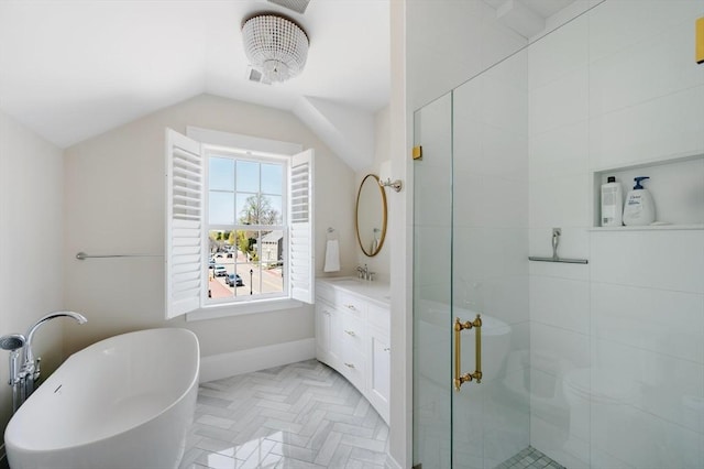 bathroom featuring a freestanding bath, vanity, vaulted ceiling, and a stall shower
