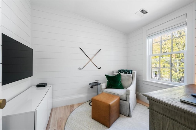 sitting room featuring visible vents, plenty of natural light, light wood finished floors, and lofted ceiling