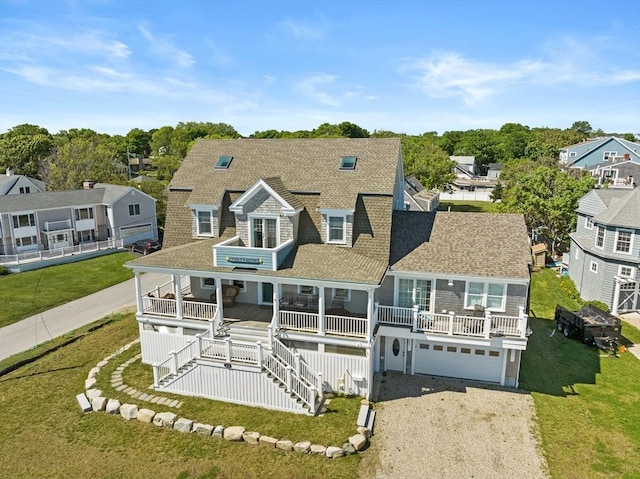 back of house featuring a garage, a yard, and a porch