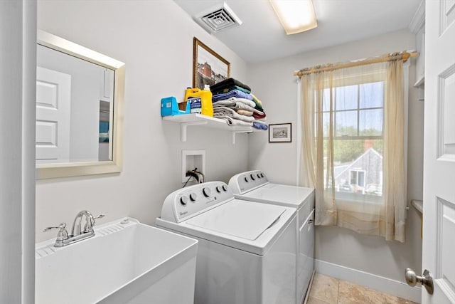 laundry area featuring sink, washing machine and clothes dryer, and light tile patterned flooring