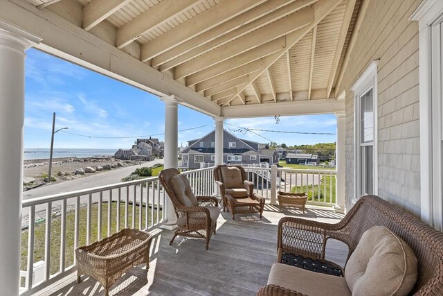 wooden deck with a water view and a porch