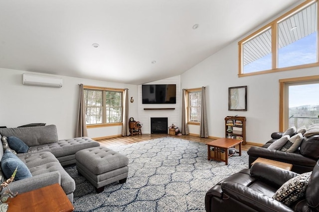 living room with high vaulted ceiling, a wall unit AC, a fireplace, wood finished floors, and baseboards