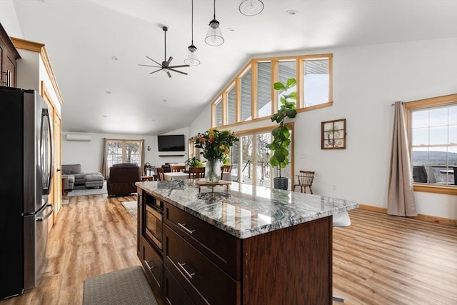 kitchen with light wood-style floors, freestanding refrigerator, dark brown cabinetry, ceiling fan, and high vaulted ceiling