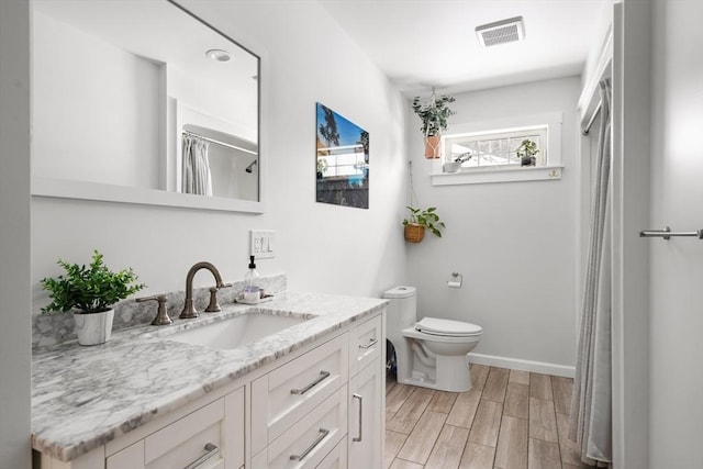 full bath featuring baseboards, visible vents, toilet, wood finished floors, and vanity