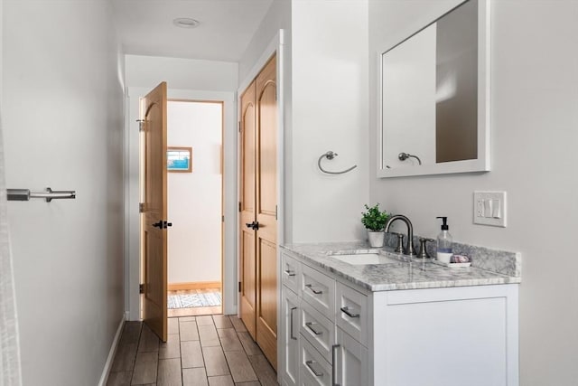 bathroom featuring wood tiled floor, baseboards, and vanity