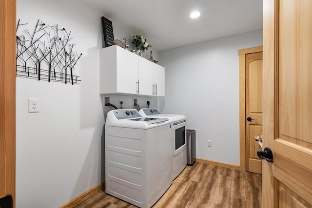 washroom featuring cabinet space, light wood finished floors, baseboards, washer and clothes dryer, and recessed lighting