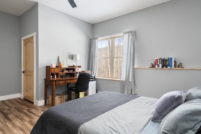 bedroom featuring a ceiling fan, baseboards, and wood finished floors