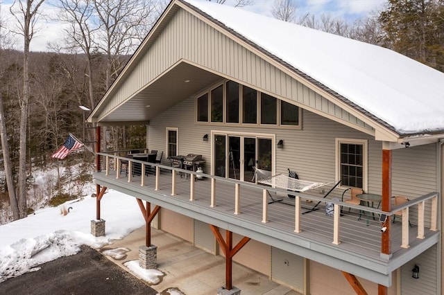 snow covered house featuring a deck