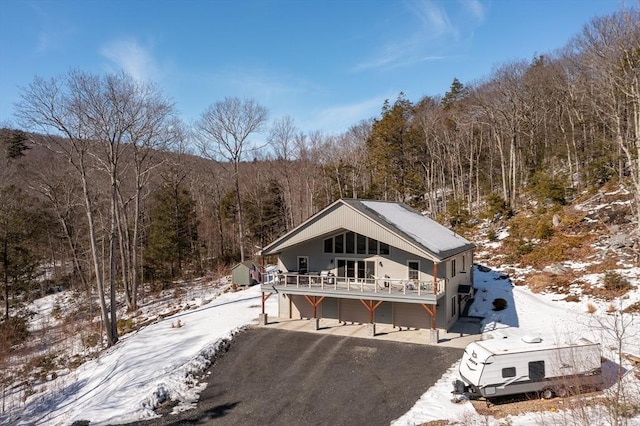 exterior space with driveway, a garage, and a wooded view