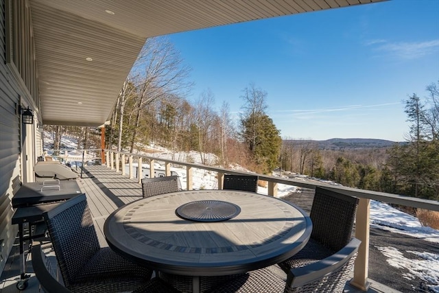 balcony with a forest view and outdoor dining area