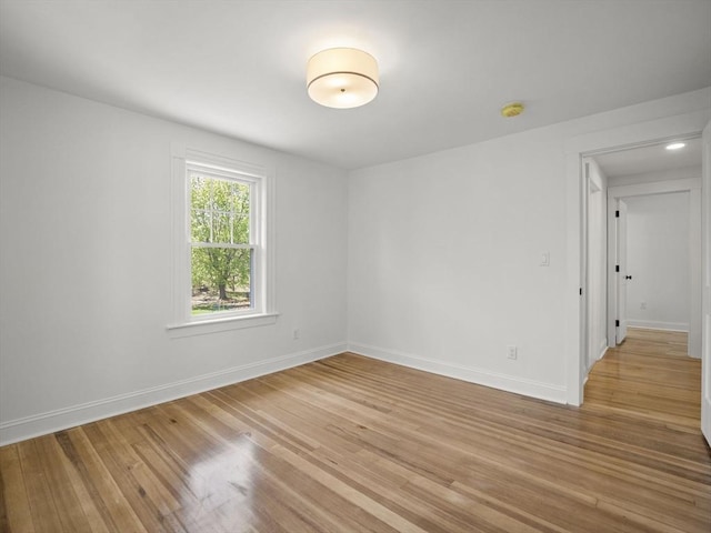 unfurnished room featuring baseboards and light wood finished floors