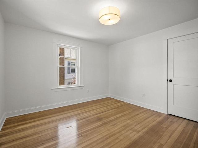 empty room with baseboards and light wood finished floors